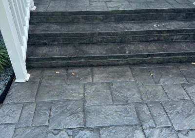 Gray stamped concrete steps leading to a porch with a white door and house number 360.